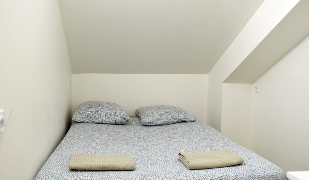 Chambre lit double linge beige du gîte les Romarins du Mas Soli à Caderousse